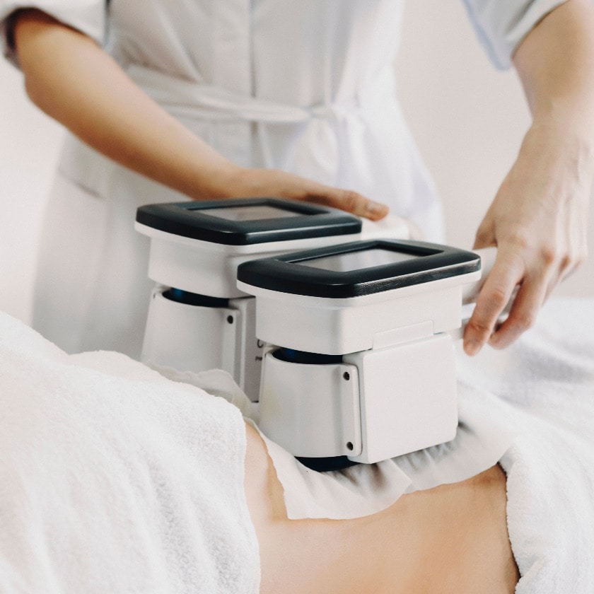 Adult woman doing cryolipolysis fat treatment procedure in a sal